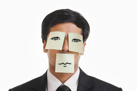 Businessman covered with adhesive notes on eyes and mouth