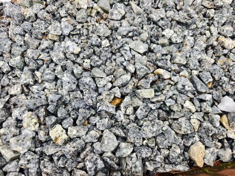 Full frame background of gray crushed granite stone gravel texture, ideal for construction and architectural landscaping concepts.