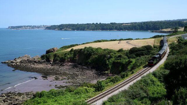 Tourism video showing a steam train in South Devon pulling historic carriages along the spectacular coastal rail lines of south Devon. Railway transportation. 