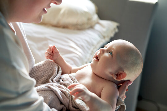 Mother holding cute baby girl at home