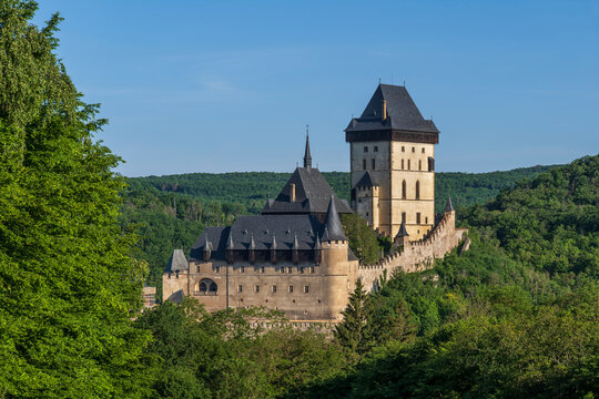 Historic Karlstejn Castle stands in a green forest in Czechia
