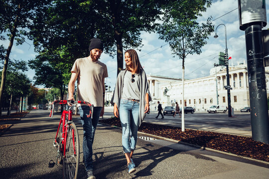 Austria, Vienna, young couple with bicycle in front of Parliament building