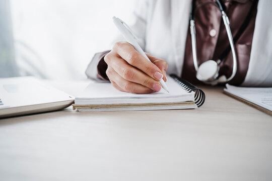 Female medical professional writing in diary