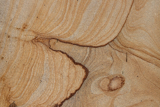 Natural wavy textured brown sandstone surface background with abstract mineral grain lines