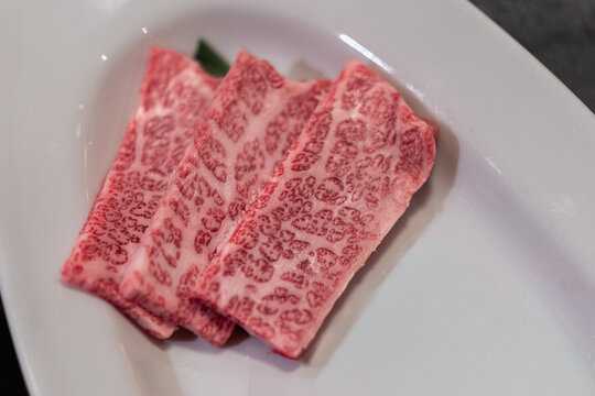 Premium Hida Wagyu Beef Marbled Raw Slices on White Plate in Japan