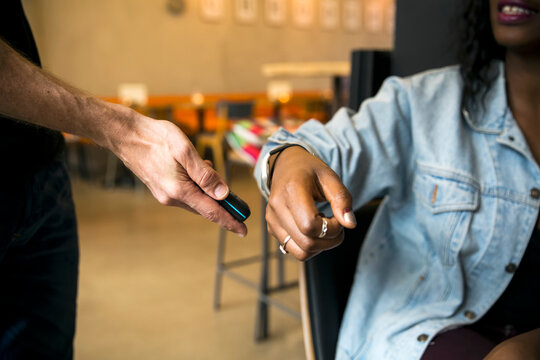 Woman paying with smartwatch and NFC reader