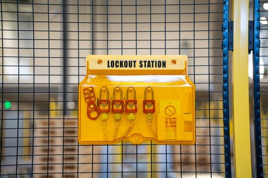 Lockout safety station with safety locks on industrial machine fence