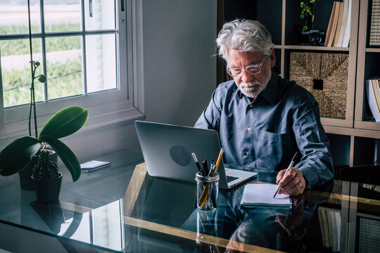 Businessman writing on note pad while working at home