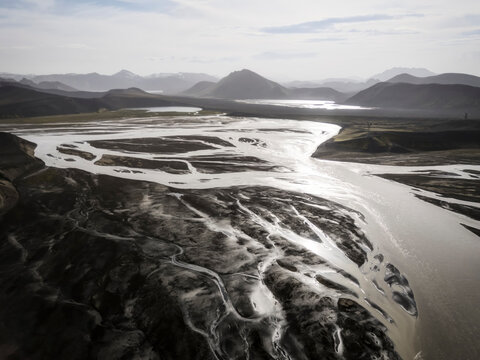 A braided river flows through black volcanic sands in Iceland