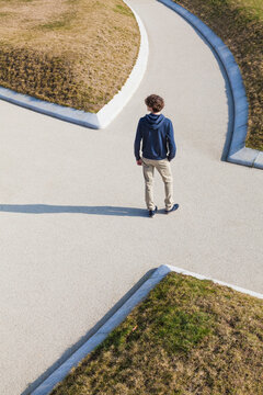 A male stands at an intersection in a Stuttgart park