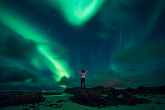 Norway, Lofoten Islands, Eggum, northern lights, young man with raised arms