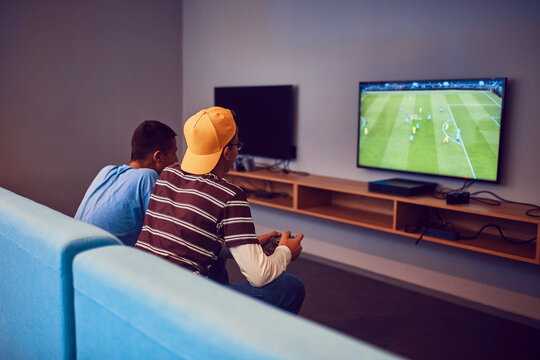 Teenage friends playing video game in an amusement arcade