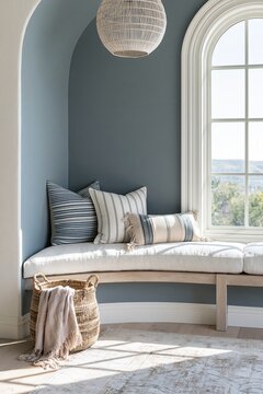 Modern Coastal style bench nook with curved bleached oak seating, striped cushions, and a large window illuminating the space