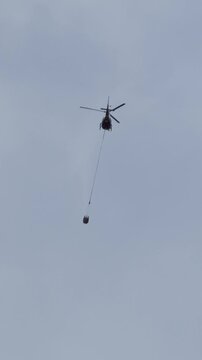 Intense long-shot view of multiple emergency helicopters battling thick dark smoke and raging flames in a dense woodland blaze
