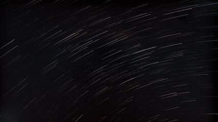 Circular star trails across a dark night sky captured with long exposure astrophotography, creating a dynamic celestial background. © gapprrraaaaa 
