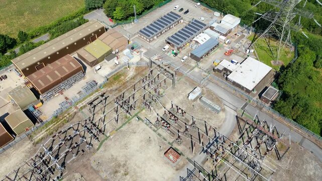 Close up aerial view of electrical substation infrastructure, high voltage transformers and busbars
