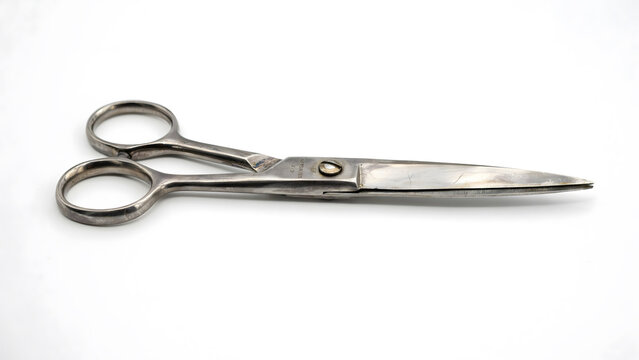 A pair of professional steel sewing scissors on a clean white background