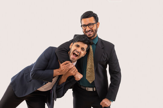 Corporate employees in formal business suit having fun with one playfully wrapping his hand around other's neck.