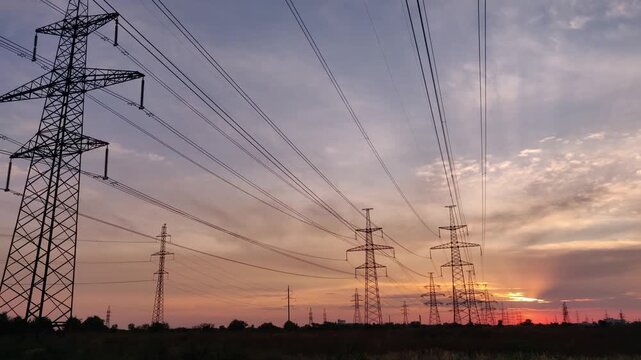 Beautiful orange sunset and power lines, electricity transmission, large power transmission towers, electrician
