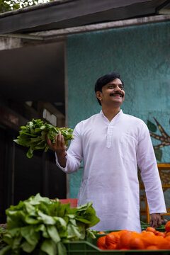 Middle age man shopping spinach in market