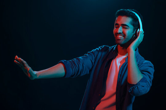 Young man listening music in headphone with eye closed