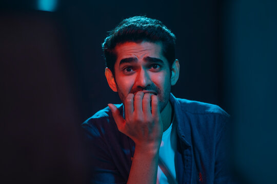 Portrait of a shocked and surprised man while watching horror movie in the movie theater