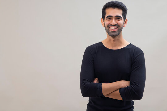 Portrait of a happy smiling young man looking at the camera with crossed hands