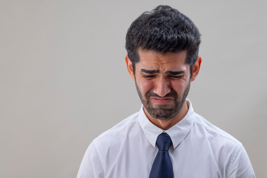 Portrait of a sad young man looking down and crying