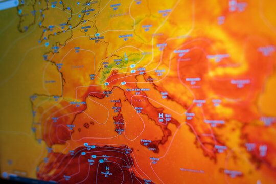 Angled close-up of a digital screen showing a European weather map with extreme heat. Red and orange colors visualize global warming, climate change, and anomalous summer heatwaves.