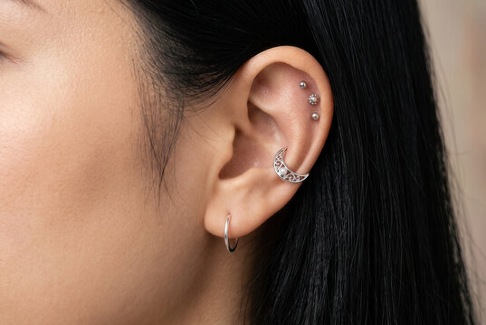 Woman Wearing Multiple Silver Ear Piercings and Crescent Cuff
