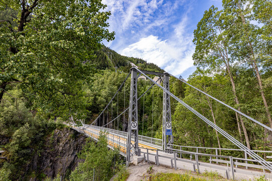 Steel bridge spans lush green valley