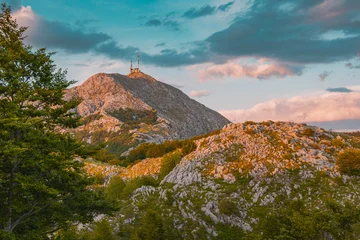 Rocky Lovcen mountain landscape with communication antennas on peak, illuminated by warm evening sun in Montenegro © EdNurg