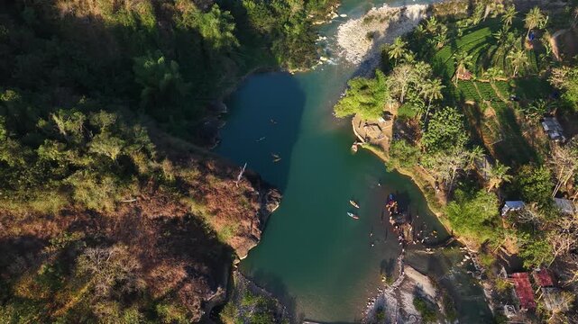 A cinematic aerial view of the Oya Valley in Kedungjati, a tranquil and clean river and canoeing destination. Located in Sriharjo, Bantul, Indonesia.