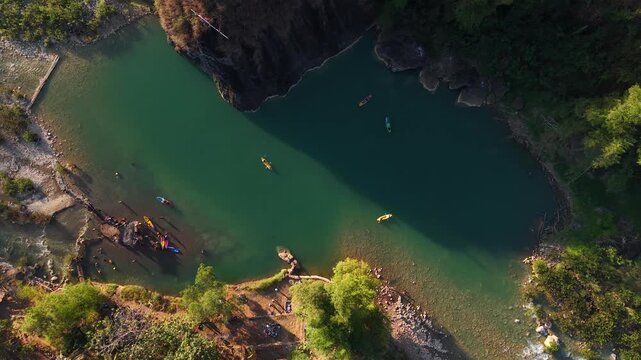 A cinematic aerial view of the Oya Valley in Kedungjati, a tranquil and clean river and canoeing destination. Located in Sriharjo, Bantul, Indonesia.