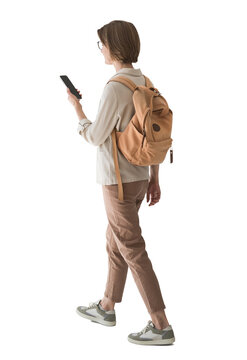 Full length portrait of a young woman walking and using phone isolated transparent PNG, student girl full body photo PNG with transparent background precisely cut out with clipping path.