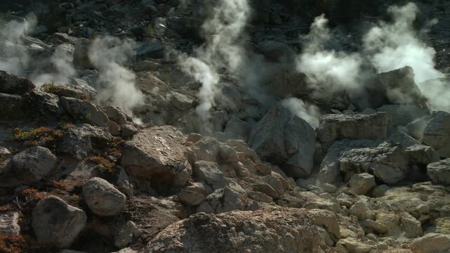 Steaming fumaroles and active geothermal vents in Lassen Volcanic National Park, California, USA with sulfuric steam rising through rocky volcanic terrain. Static shot