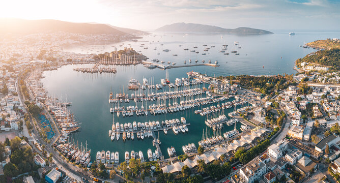 Bodrum, Turkiye marina packed with numerous yachts and sailing vessels, featuring castle and coastal city along the Aegean Sea