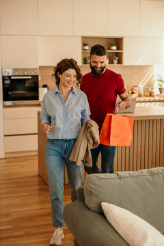 Couple arriving home from shopping, smiling and happy