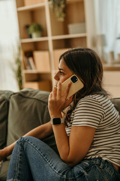 Young woman calling with smartphone connecting from home