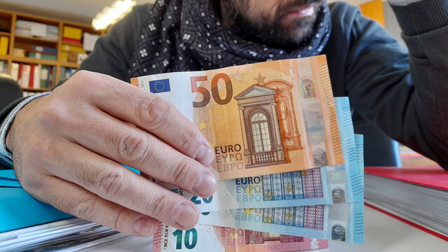 Banconote da 20 e 50 euro nelle mani di un uomo - business