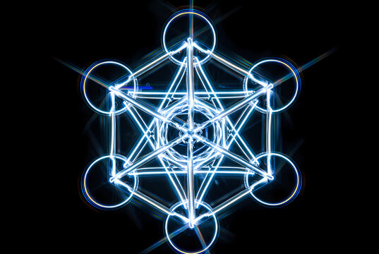 A glowing blue geometric shape with interconnected lines and circles on a black background