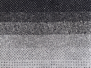 Close up of a soft woven terry towel featuring a textured gradient of horizontal color block stripes in black, charcoal, and grey. © TMR Studio