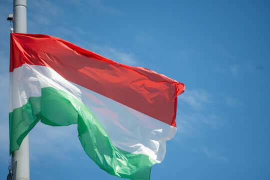 Hungarian National Flag Waving in Blue Sky