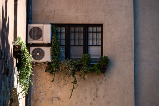 Old Window with Air Conditioning Units and Plants