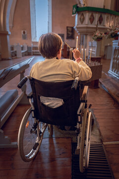 Wheelchair user lighting a candle inside a historic Lutheran church