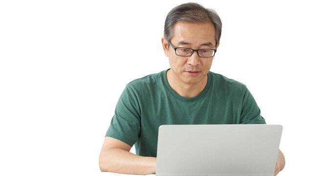 Senior Asian man using laptop on transparent background. Isolated. Concentrated mature man working on computer.