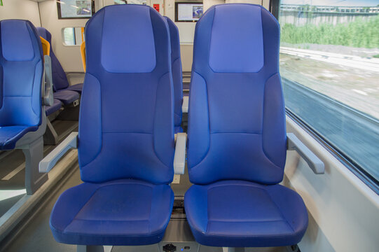 Empty blue seats in modern train interior traveling