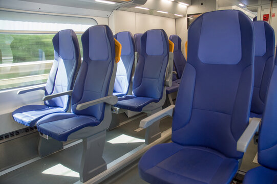 Empty blue seats in modern train interior traveling