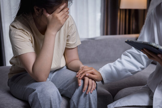 Caregiver listening with empathy and recording depression symptoms in a notebook, mental health care, patient support, psychology, treatment, recovery, resilience, wellbeing.