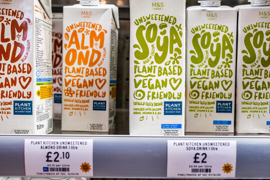 Close-Up Shot Of A Product Display Of Unsweetened Soya Milk And Almond Milk Plant-Based Dairy Alternatives On A Supermarket Shelf With Priice Tags, No People